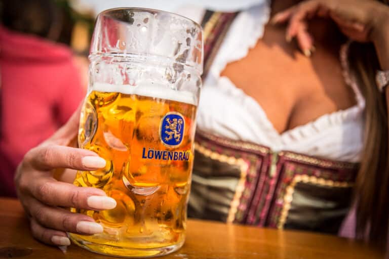 Frau im Dirndl mit einer Maß Bier in der Hand auf dem Münchner Oktoberfest.